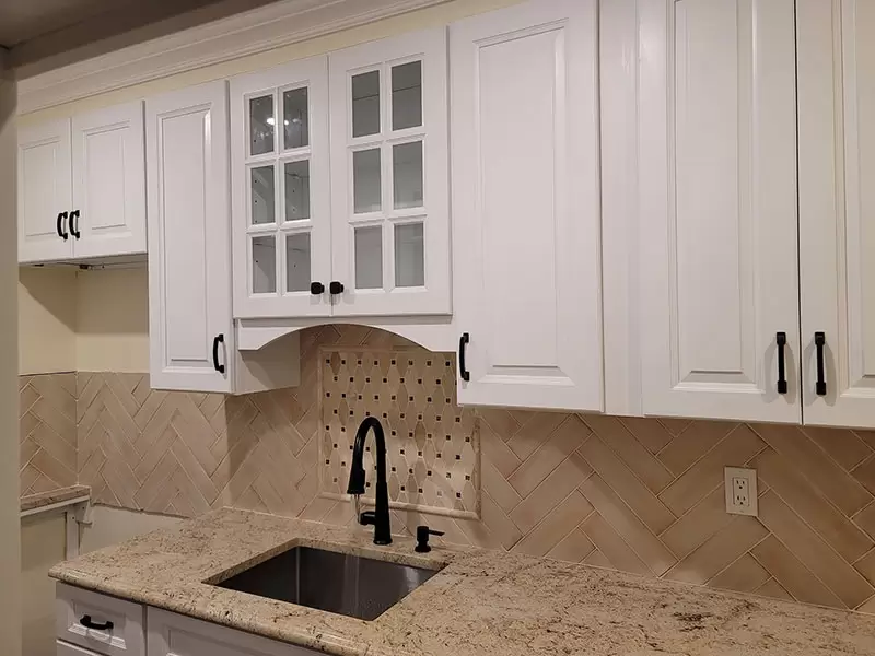 Kitchen cabinet, sink, counter, and backsplash detail